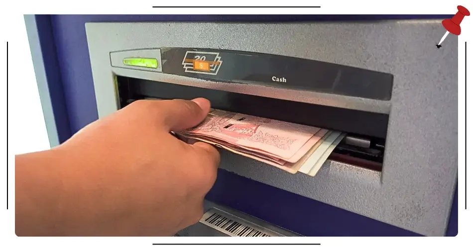 Kobieta w trakcie wypłaty pieniędzy z bankomatu